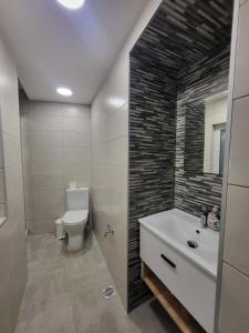 La salle de bains est pourvue de toilettes blanches et d'un lavabo. dans l'établissement St Julian Apartments, à San Ġiljan