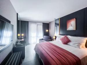 a hotel room with a large bed and a chair at Belcekiz Beach Club - All Inclusive in Oludeniz