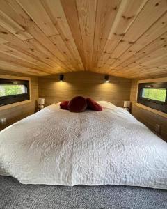 um quarto com uma cama grande e um tecto em madeira em La Tiny House de Nanou em Rochefort