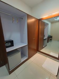 ein Zimmer mit einem leeren Schrank mit einer Tür und einem Zimmer mit einem Tisch in der Unterkunft Ponneri Gymkhana Club in Ponneri