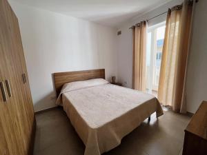 馬爾薩斯卡拉的住宿－Modern Apartment in Marsaskala，一间卧室设有一张床和一个大窗户