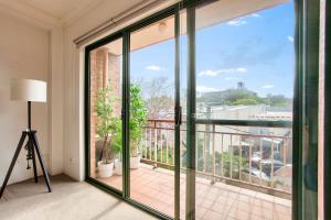 um quarto com uma varanda com portas de vidro deslizantes em Cozy 2 Bedroom Apartment Surry Hills em Sydney