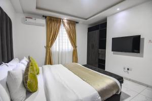 a bedroom with a bed and a flat screen tv at Luxury 1 bedroom apartment in the heart of lekki in Lekki