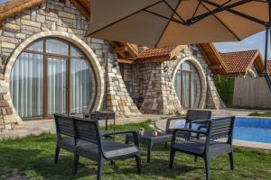 a group of chairs and a table with an umbrella at Amazing Stone House with Private Pool in Iznik in İznik