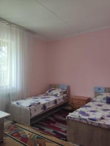 a bedroom with two beds and a window at Азия Hotel in Taraz