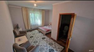 a living room with a mirror and a bedroom at Азия Hotel in Taraz