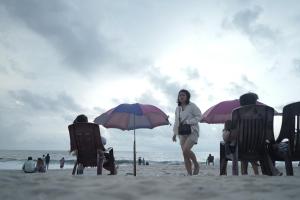 a woman standing on a beach with chairs and umbrellas at Marari Red Angel in Mararikulam +83 photos