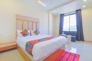 a bedroom with a large bed and a large window at FabHotel Bohra International in Jaipur +27 photos