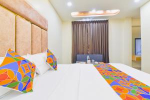 a hotel room with a bed with colorful pillows at FabHotel Bohra International in Jaipur