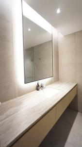 baño con lavabo y espejo grande en ManukabyHavis Boutique Hotel, en Nagoya