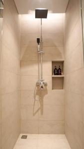 um chuveiro com uma porta de vidro na casa de banho em ManukabyHavis Boutique Hotel em Nagoya
