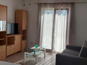 sala de estar con sofá y mesa de centro de cristal en Apartman Figaro sa dva kupatila uz more i plažu s pogledom na Split, en Kaštela