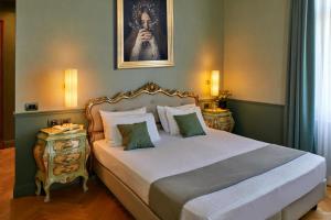 a bedroom with a bed and a portrait of a woman at Hotel Villa Del Sogno in Gardone Riviera