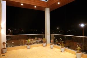 a balcony with potted plants and a view of the night at HOTEL RADHIKA in Dwarka