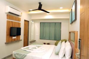 a hotel room with a bed and a television at HOTEL RADHIKA in Dwarka