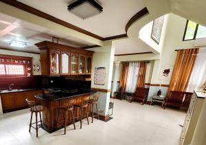 a kitchen with a bar with stools in it at Leynes Taal Lake Resort and Hostel in Tanauan