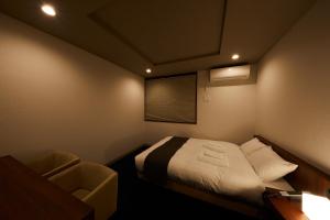 Cette petite chambre comprend un lit et une chaise. dans l'établissement HOTEL SUHAANA, à Giommachi