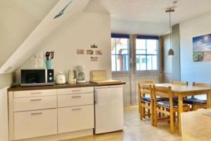 a kitchen with white cabinets and a table and a dining room at Holiday resort Lemkenhafen, Fehmarn-Lemkenhafen in Lemkenhafen auf Fehmarn
