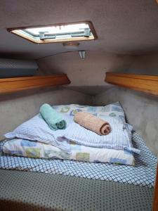 uma pequena cama num quarto com uma janela em Location Unique : Le Bateau d'Antoine à Roscoff em Roscoff