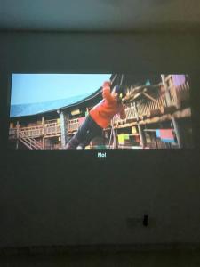 einen Fernsehbildschirm mit einem Bild einer Person darauf in der Unterkunft Home Cinema, Karaoke, Swimming Pool, near KLCC in Kuala Lumpur