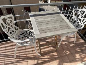 d'une table et de chaises en bois sur un balcon. dans l'établissement Nest & Relax, à Trente