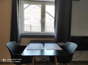 a table and a chair in front of a window at Studio calme à proximité des 7 meuses in Profondeville