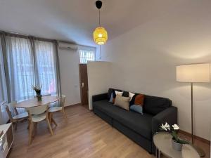 un soggiorno con divano e tavolo di Nice apartment on street level in Vallecas. PNu a Madrid