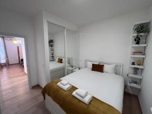 1 dormitorio con 1 cama blanca y 2 toallas en Nice apartment on street level in Vallecas. PNu, en Madrid