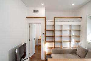 Almada Cityscape Apartment في ألمادا: غرفة معيشة مع سرير وأريكة