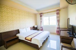 - une chambre avec un lit, un bureau et une télévision dans l'établissement Khách sạn Vĩnh Lộc, à Lào Cai