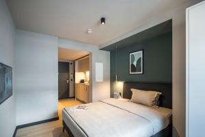 a bedroom with a large bed with a black wall at ipartment Frankfurt Central Station in Frankfurt