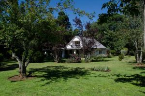 a house in the middle of a yard at Maylodge Country Cottages in Hogsback