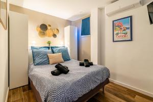 een slaapkamer met een bed met blauwe kussens bij Cassis le Marignan- en rez-de-chaussée - classé 3 étoiles in Cassis