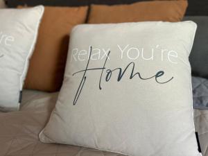 a pillow with the words relax your home on it at Kleine Auszeit in Viersen