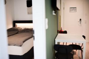 1 dormitorio con 1 cama, mesa y sillas en Homaris Apartments Elmshorn en Elmshorn