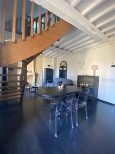 a living room with a table and chairs and a staircase at Apt cosy centre ville Bayeux avec terrasse ou extérieur proche plages du débarquement in Bayeux