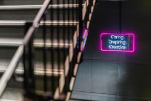 a neon sign that says caring interpreting preserve on a staircase at Aiden by Best Western Trondheim Airport in Stjoerdal