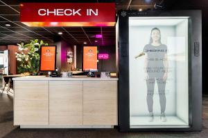 un panneau pour un magasin où une femme est debout sur un écran dans l'établissement Aiden by Best Western Trondheim Airport, à Stjoerdal