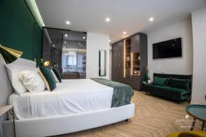 a bedroom with a white bed and a green couch at Salotto Room Boutique in Pescara