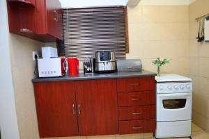 y cocina con encimera, microondas y fogones. en Manzini Chalet 39, en St Lucia
