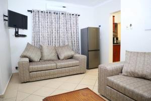 Una sala de estar con dos sofás y un televisor. en Manzini Chalet 39, en St Lucia