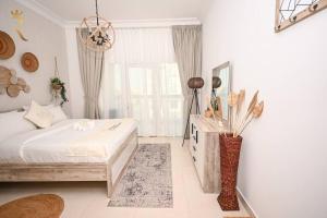 a white bedroom with a bed and a window at Yas Natura Bliss 1BR Apartment in Abu Dhabi