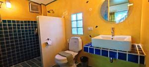 a bathroom with a toilet and a sink and a mirror at Kuad Khon Thoe Pai Cottage in Pai