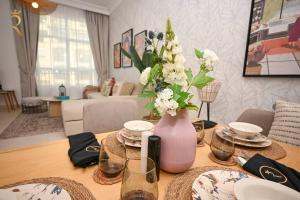 a living room with a table with a vase of flowers at Yas Natura Bliss 1BR Apartment in Abu Dhabi