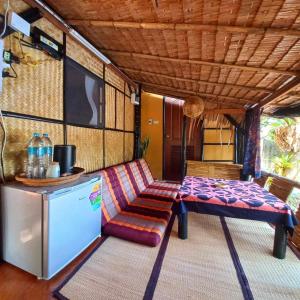Bar Horizon Hostel في شومفون: غرفة بها أريكة وطاولة وثلاجة