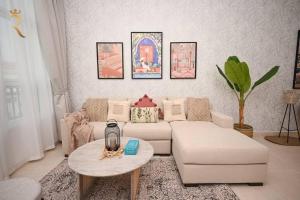 ein Wohnzimmer mit einem Sofa und einem Tisch in der Unterkunft Yas Natura Bliss 1BR Apartment in Abu Dhabi