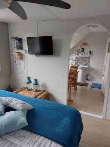 1 dormitorio con 1 cama azul y sala de estar en Bed & Breakfast d'Ouwe Smidse, en Kamperland