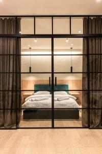 a bedroom with a large bed with glass walls at Urban Studio @ Record Park in Cluj-Napoca