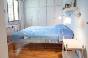 een slaapkamer met een bed met een blauw dekbed bij N269 - Numana, villa singola quadrilocale con giardino in Numana
