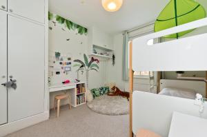 a childs bedroom with a desk and a bed at Veeve - Open Skies in London